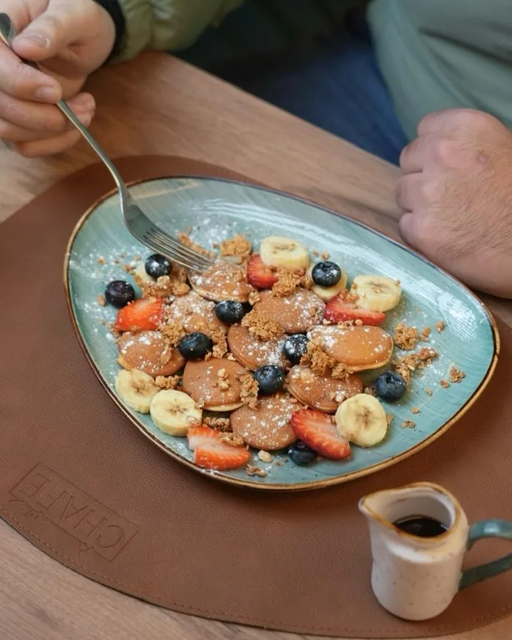 Fruity mini pancakes with banana, strawberry and blueberries