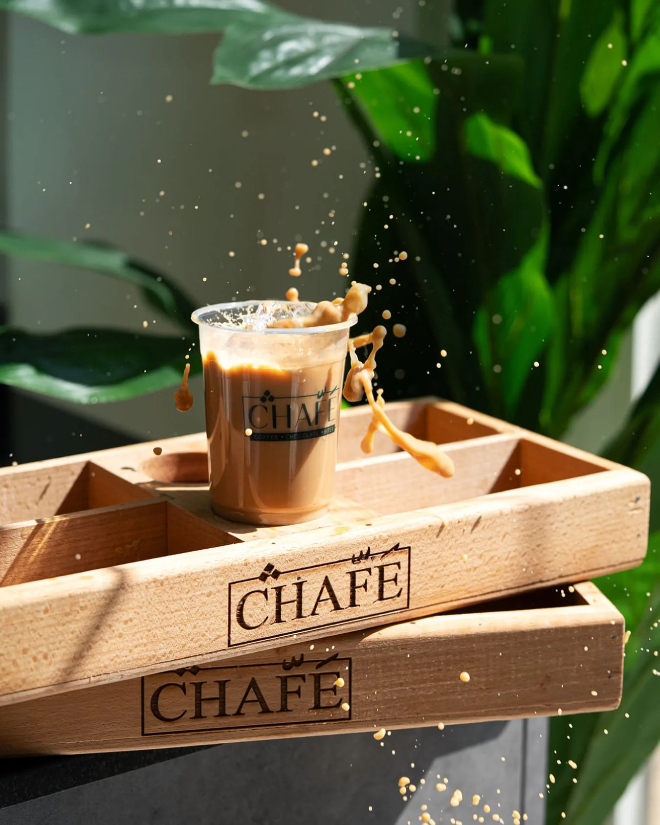 Iced coffee splashing on stacked CHAFÉ boxes