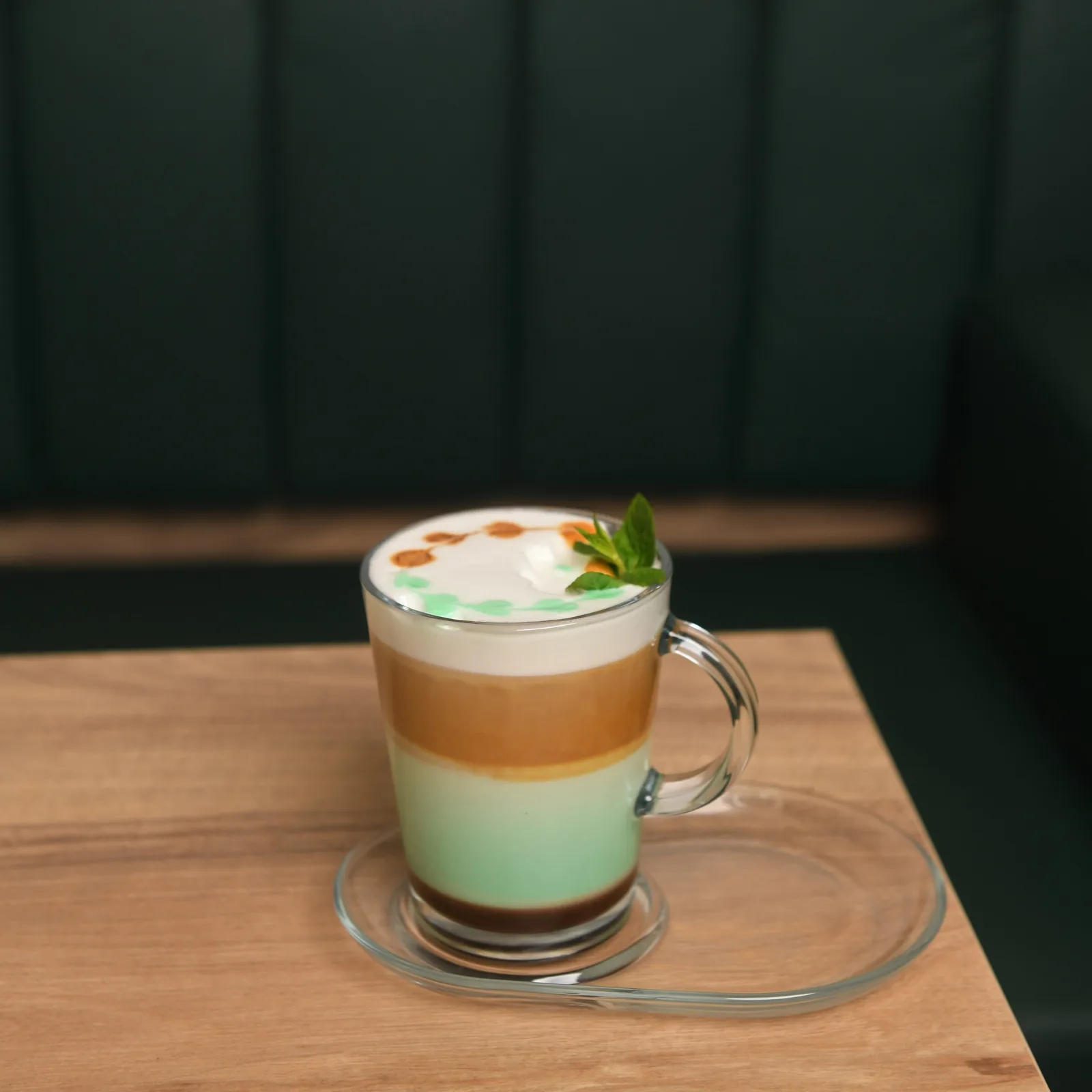 A layered latte on an oak table