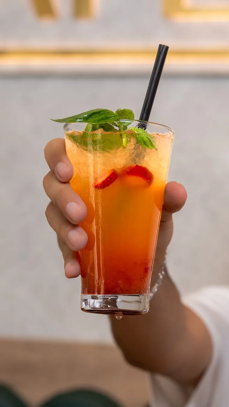 A sunset mojito with mint and strawberry