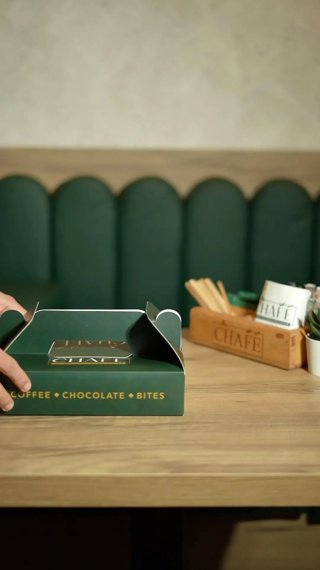 A CHAFÉ share box on the table by the green banquette