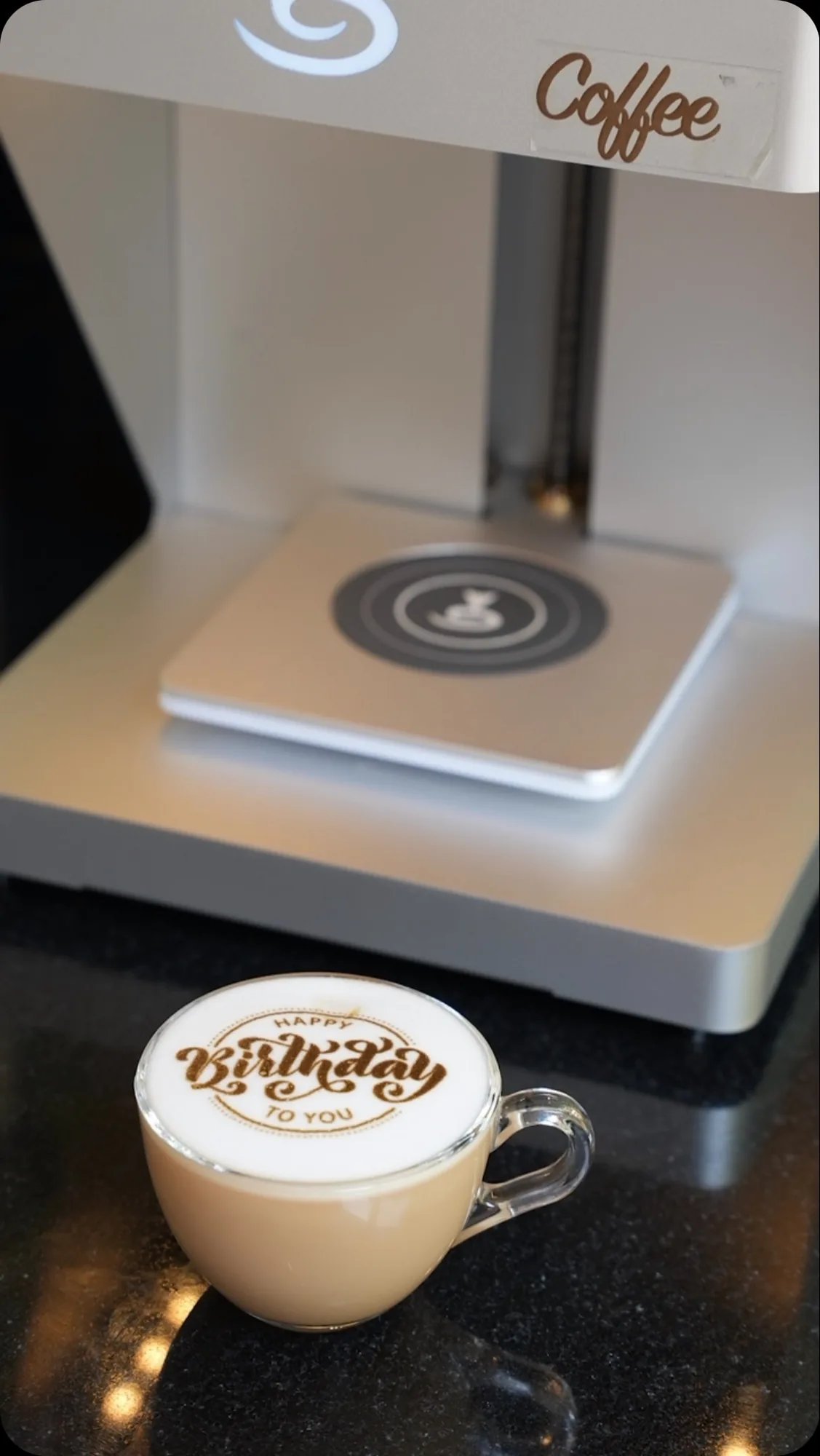 The latte printer writing Happy Birthday on foam