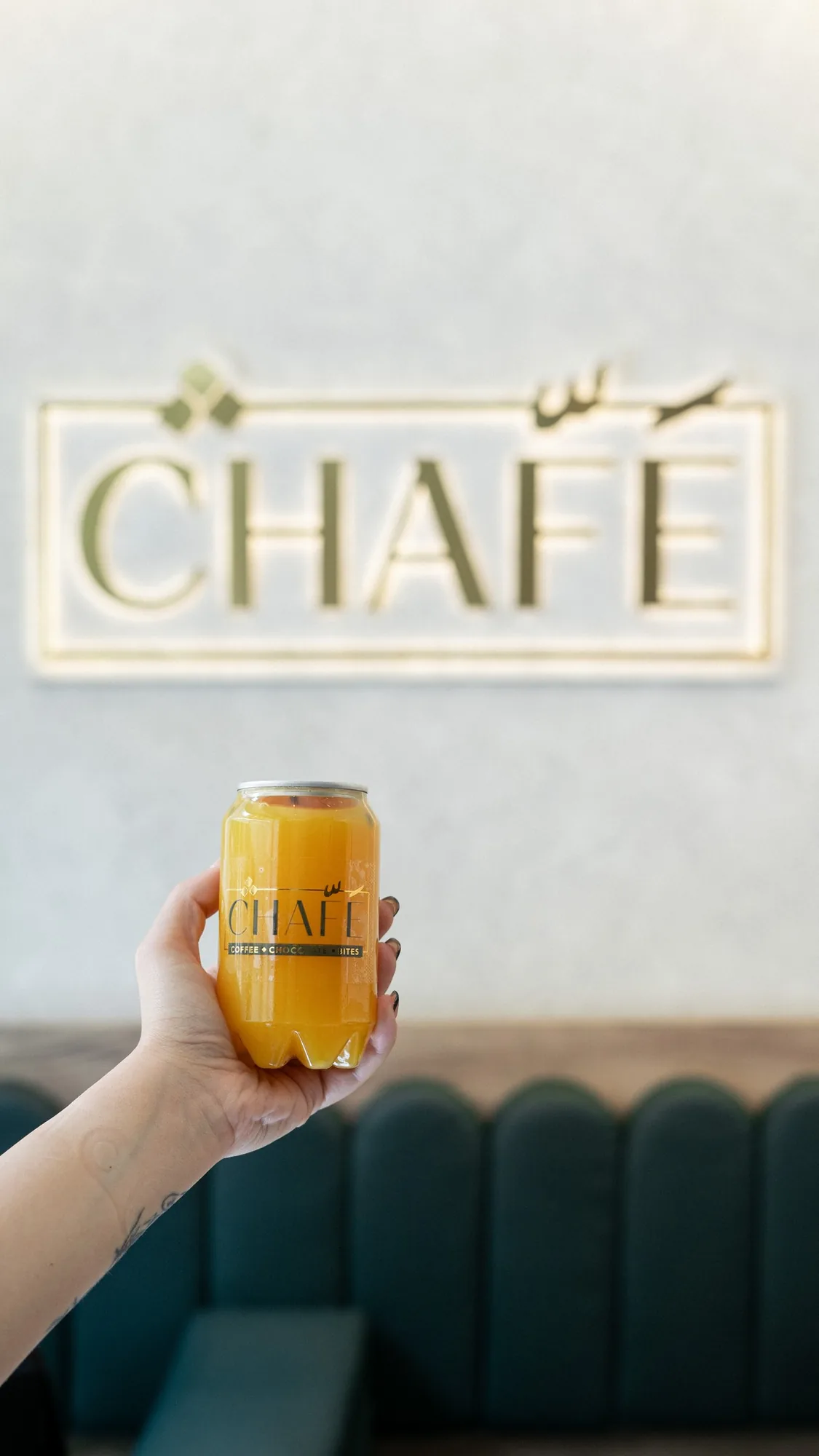 A CHAFÉ juice can held up to the frosted wordmark