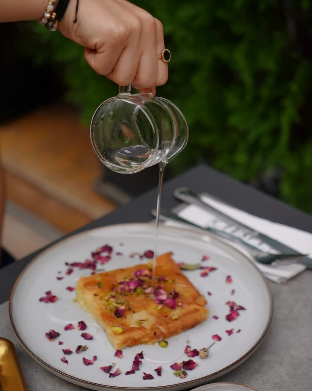 Sugar-free knefe with rose petals and a pour of syrup